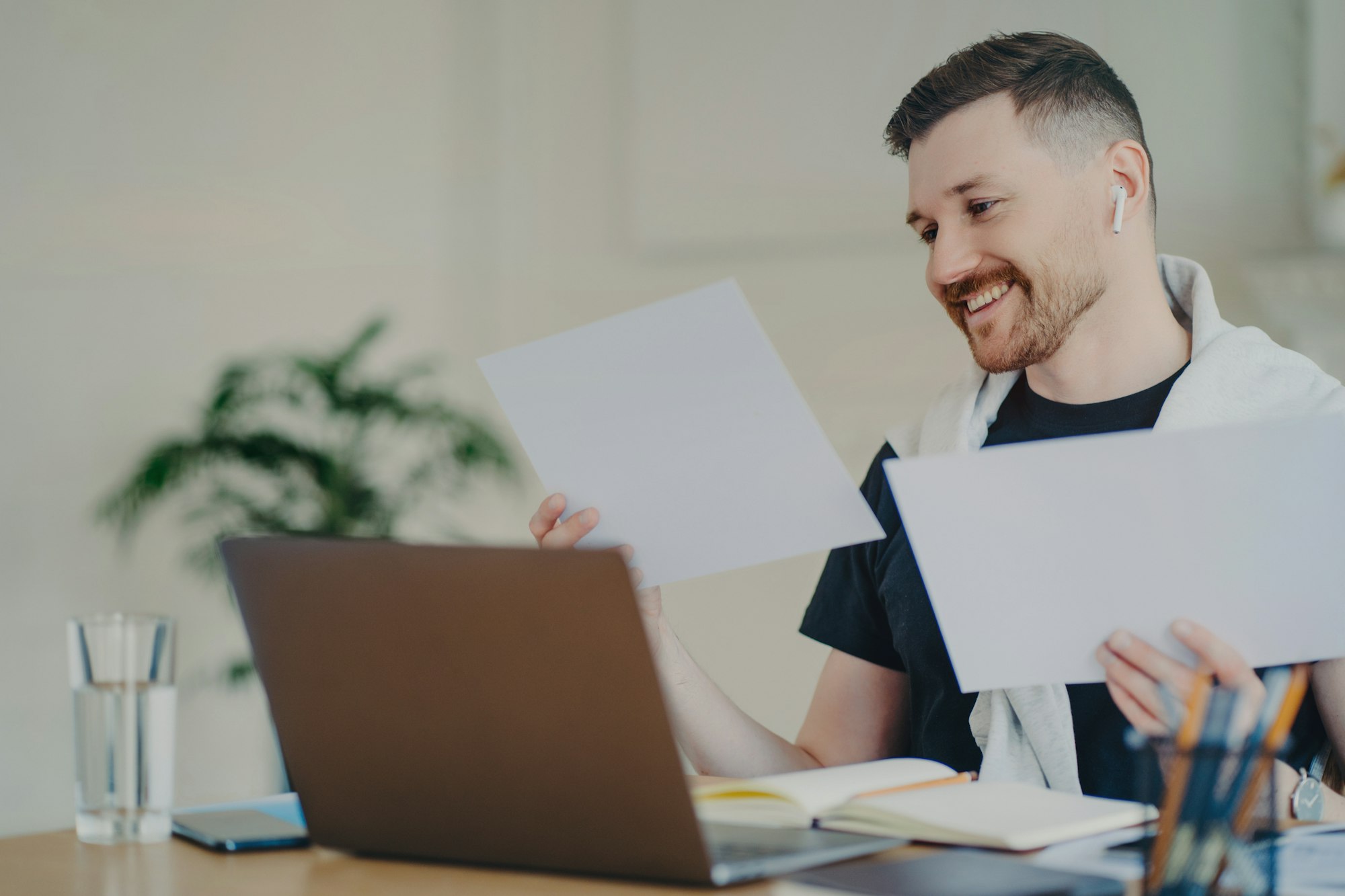 Happy entrepreneur looking at documents while working at home office
